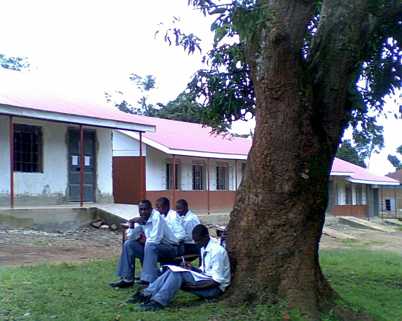 Students outside near new blocks. Could someone donate a couple of benches?